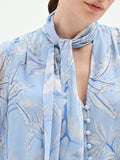 Blusa azzurra in raso con stampa foliage