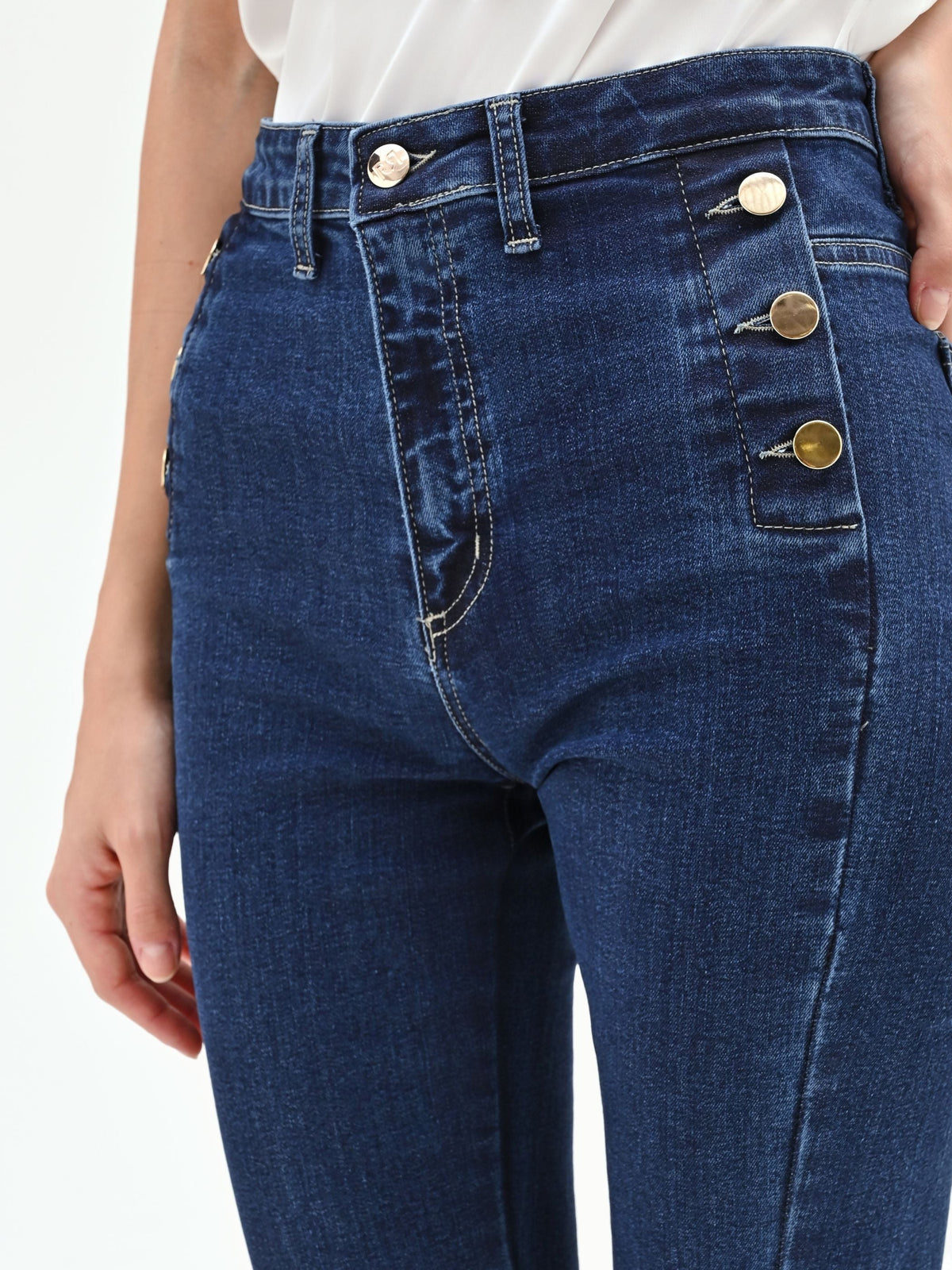Pantaloni jeans azzurri a zampa con bottoni dorati