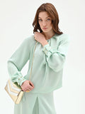 Blusa verde menta con pieghe e polsini alti
