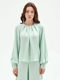 Blusa verde menta con pieghe e polsini alti