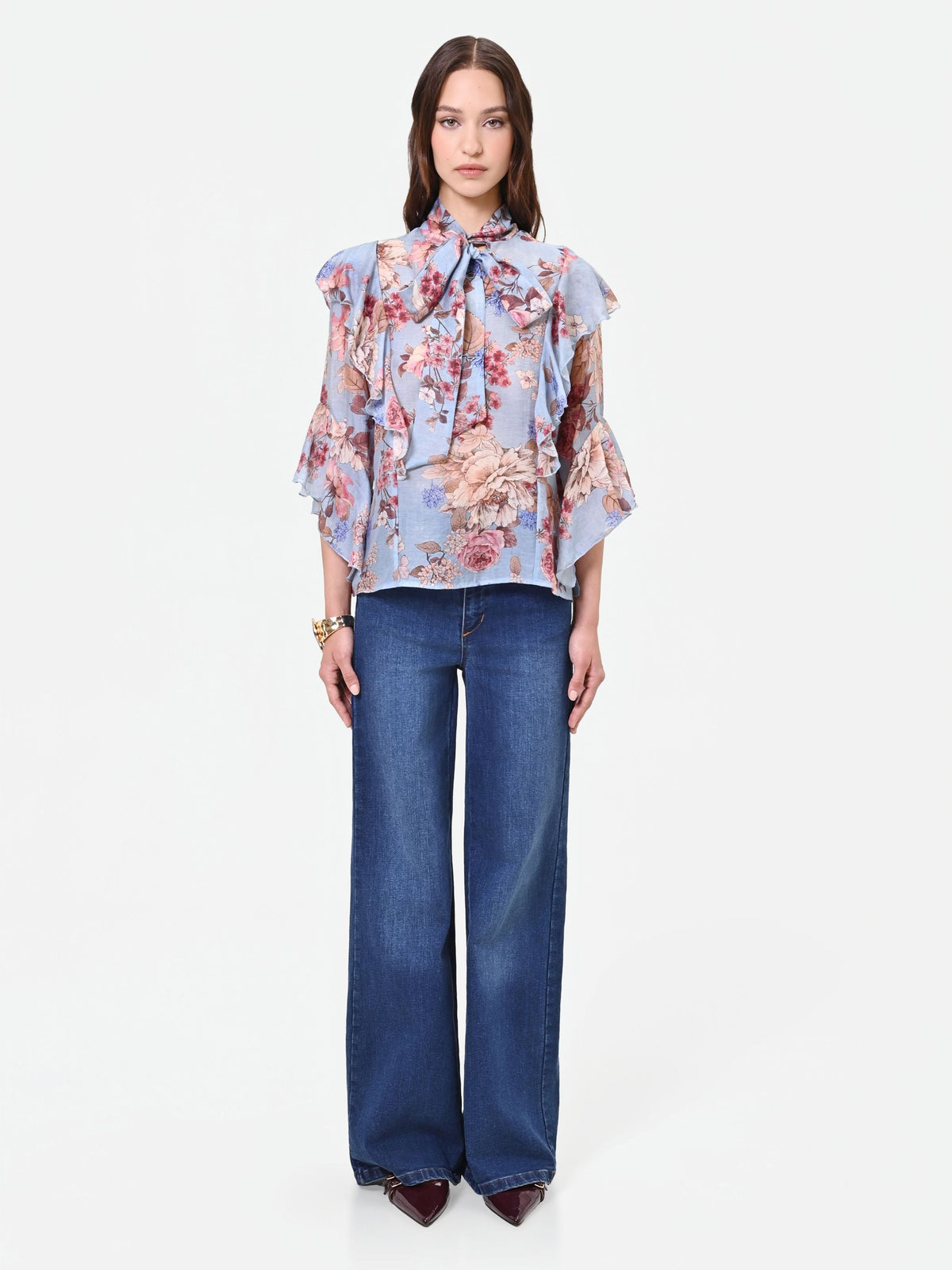 Blusa azzurra con fantasia floreale e fiocco