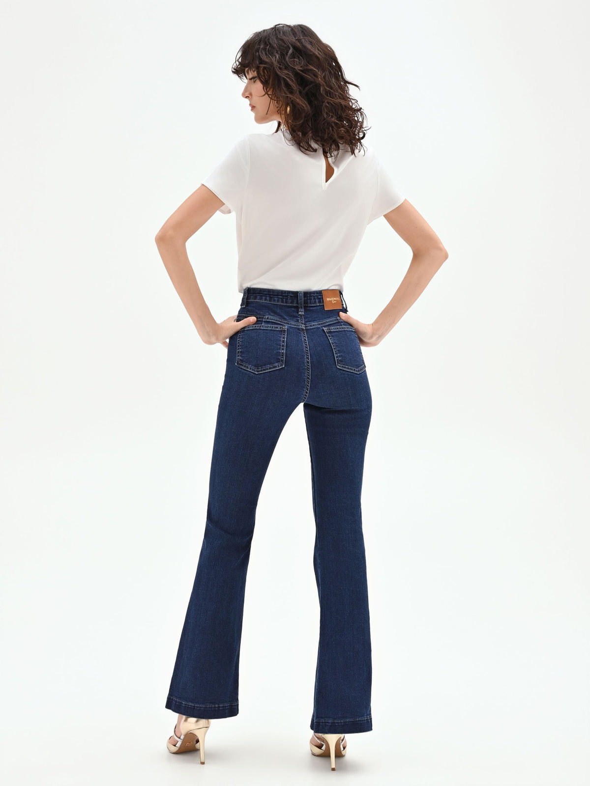 Pantaloni jeans azzurri a zampa con bottoni dorati