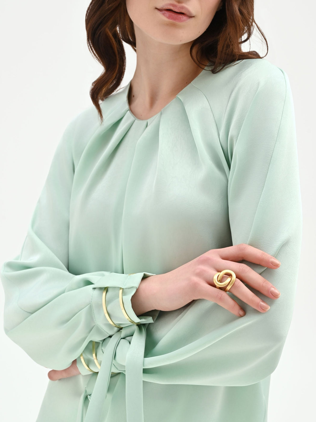 Blusa verde menta con pieghe e polsini alti