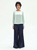 Blusa verde menta dalla linea essenziale