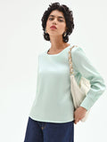 Blusa verde menta dalla linea essenziale