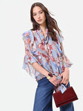 Blusa azzurra con fantasia floreale e fiocco