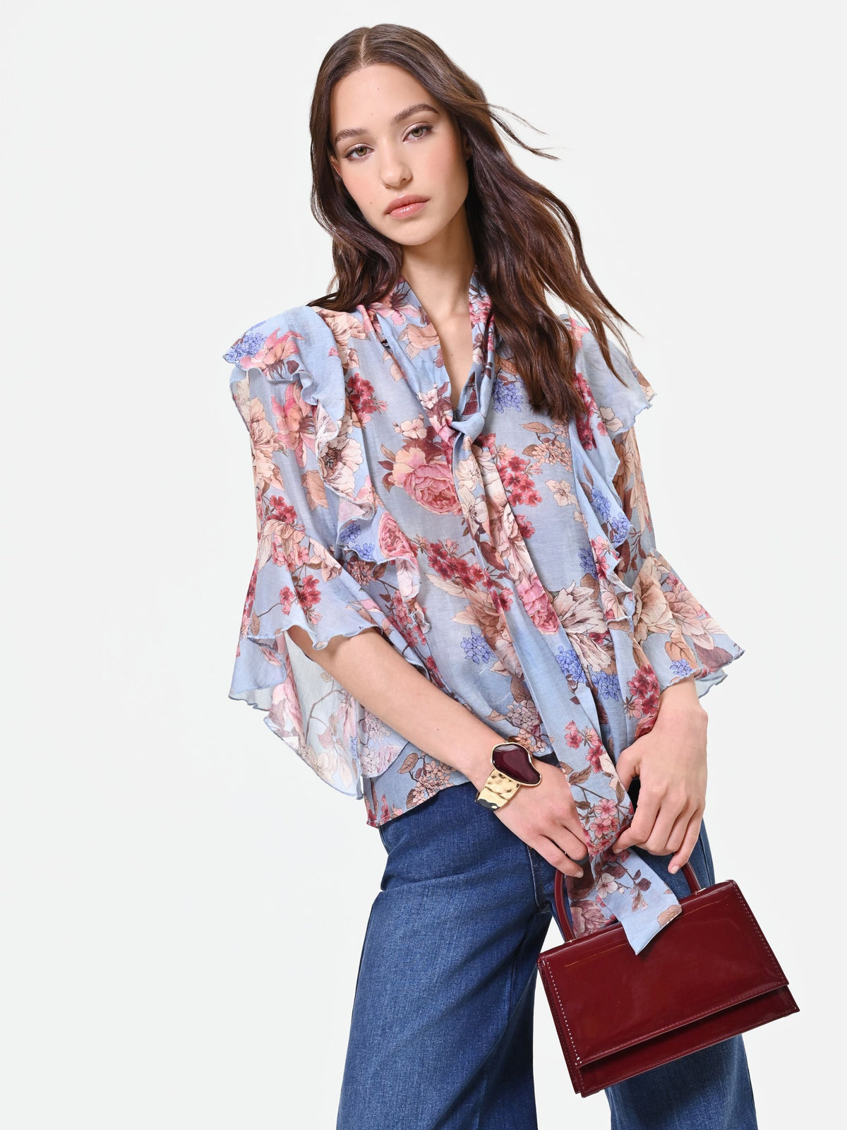 Blusa azzurra con fantasia floreale e fiocco