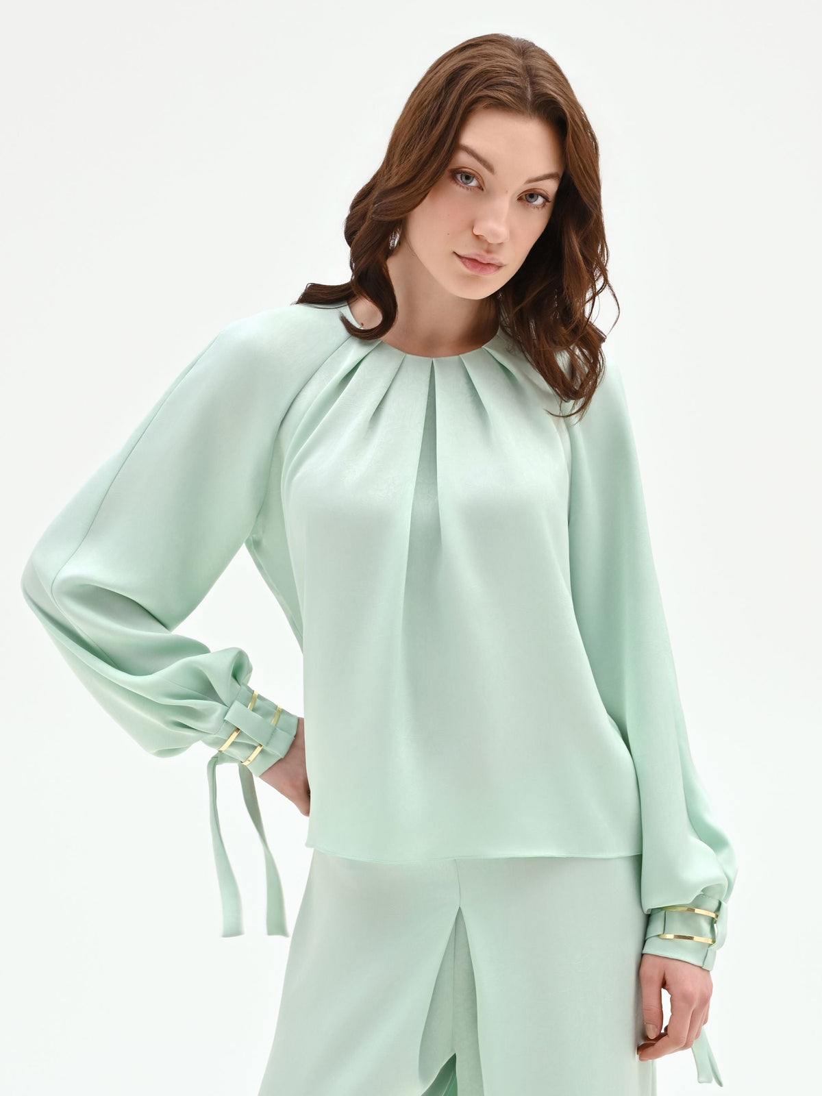Blusa verde menta con pieghe e polsini alti