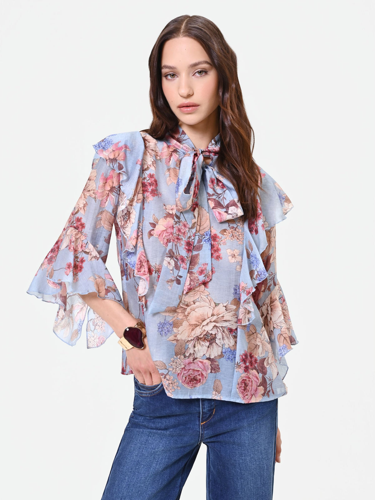 Blusa azzurra con fantasia floreale e fiocco