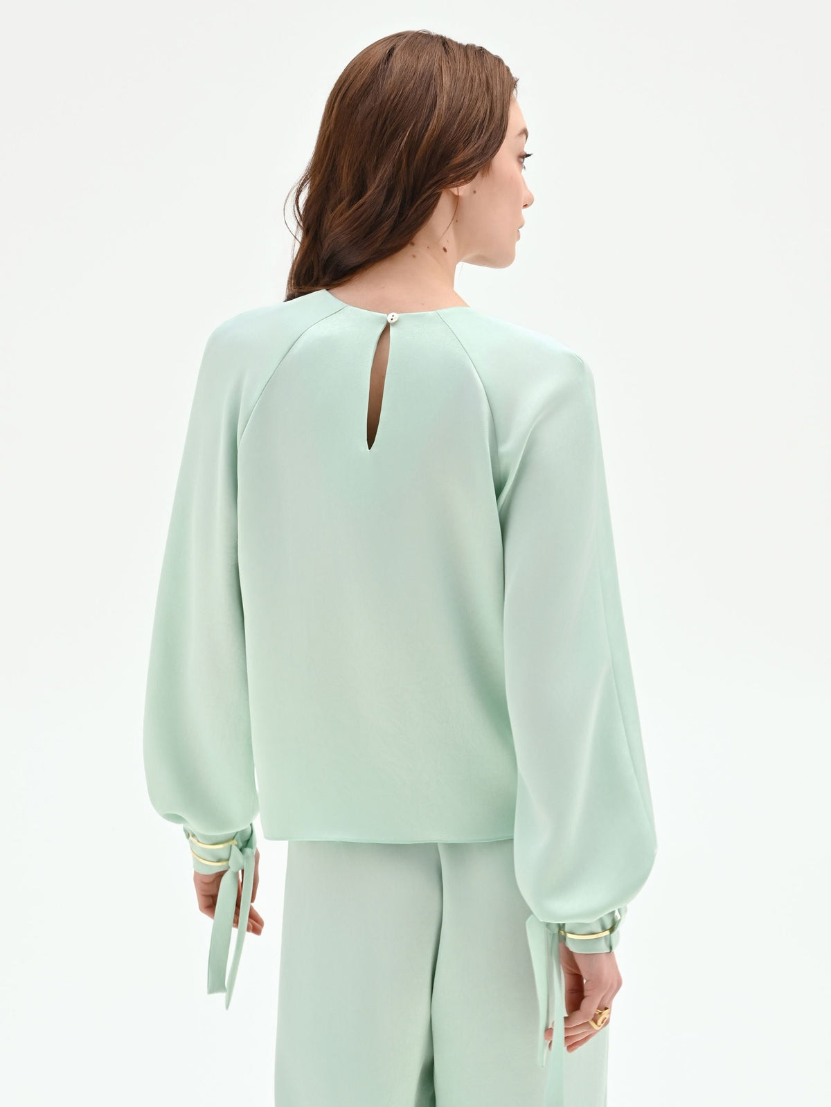 Blusa verde menta con pieghe e polsini alti