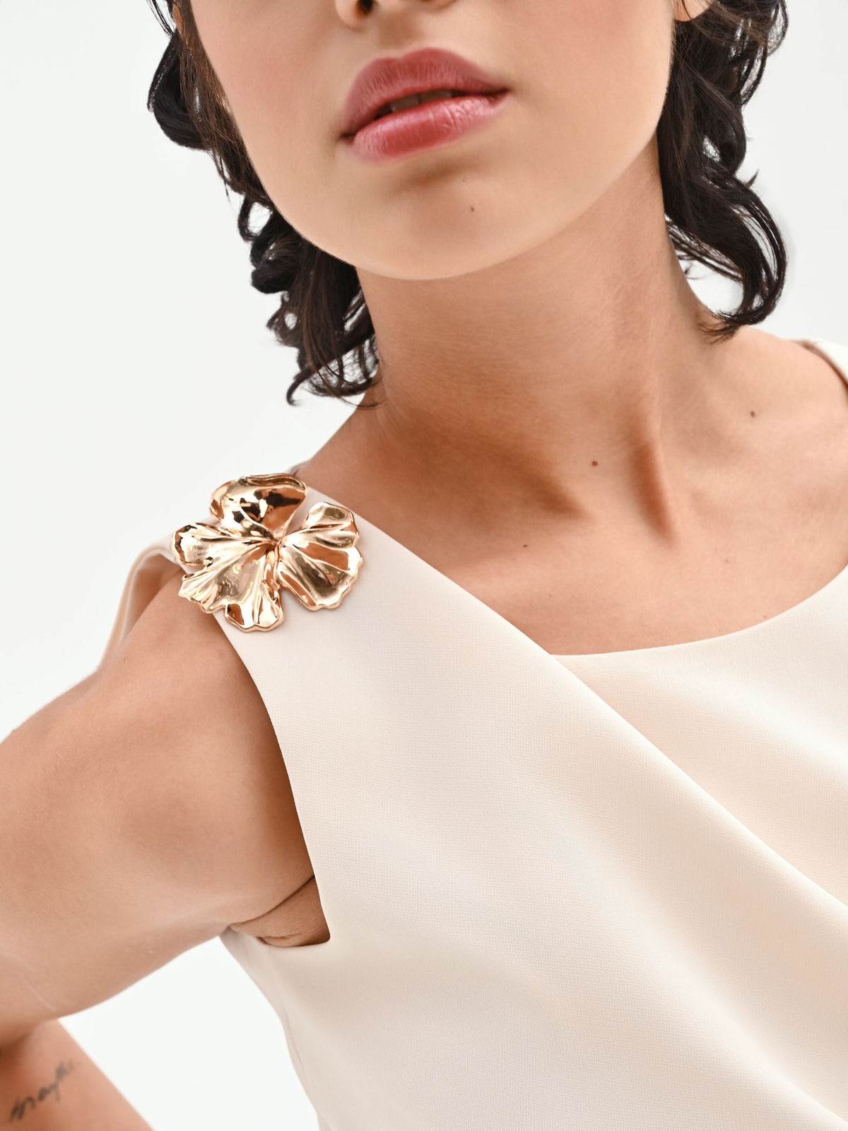 Top asimmetrico panna con accessorio oro