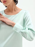 Blusa verde menta dalla linea essenziale