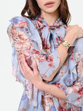 Blusa azzurra con fantasia floreale e fiocco