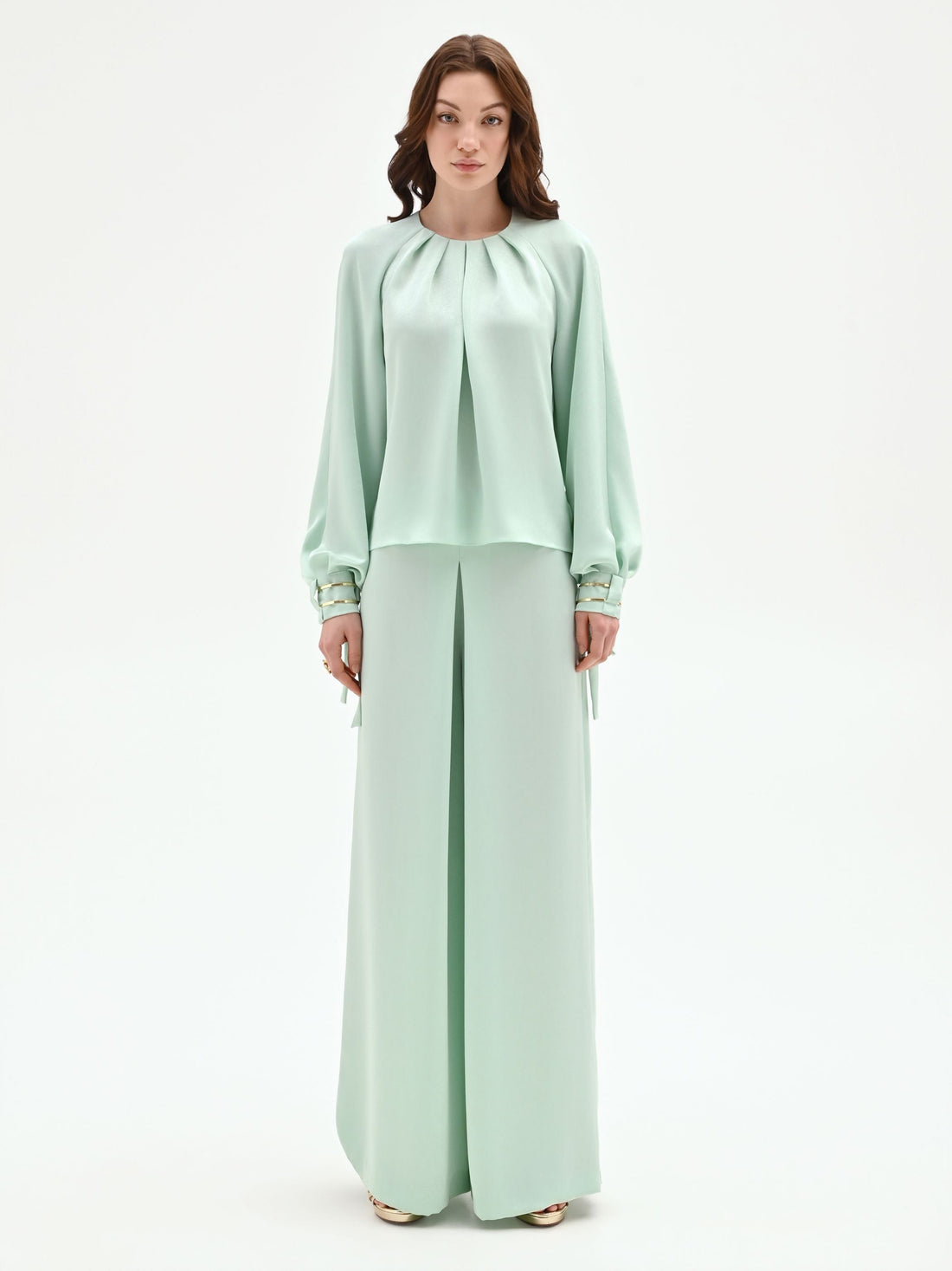 Blusa verde menta con pieghe e polsini alti