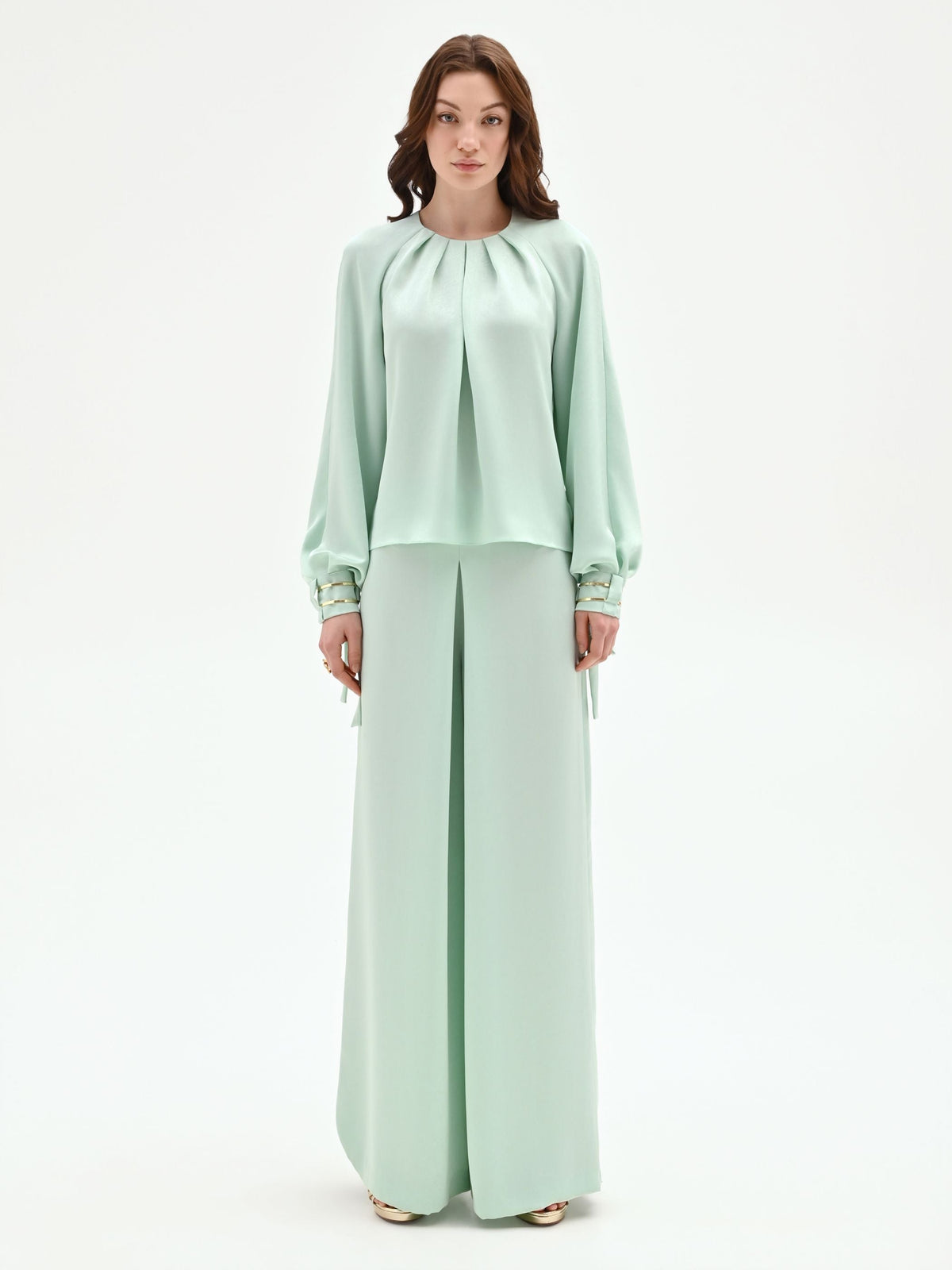 Blusa verde menta con pieghe e polsini alti
